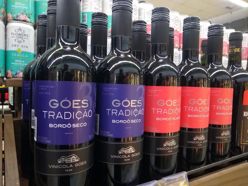 Góes Tradição Bordô Seco (à frente, em roxo). Com cortes de uva Isabel e predominância da uva bordô, obtendo-se um vinho de cor rubi intenso, aroma típico das variedades e paladar agradável. Combina com carnes vermelhas, massas, queijos e canapés.